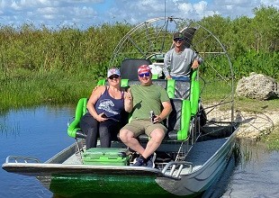 Smiling group enjoying a private 2-hour airboat tour through the Florida Everglades on a sunny day